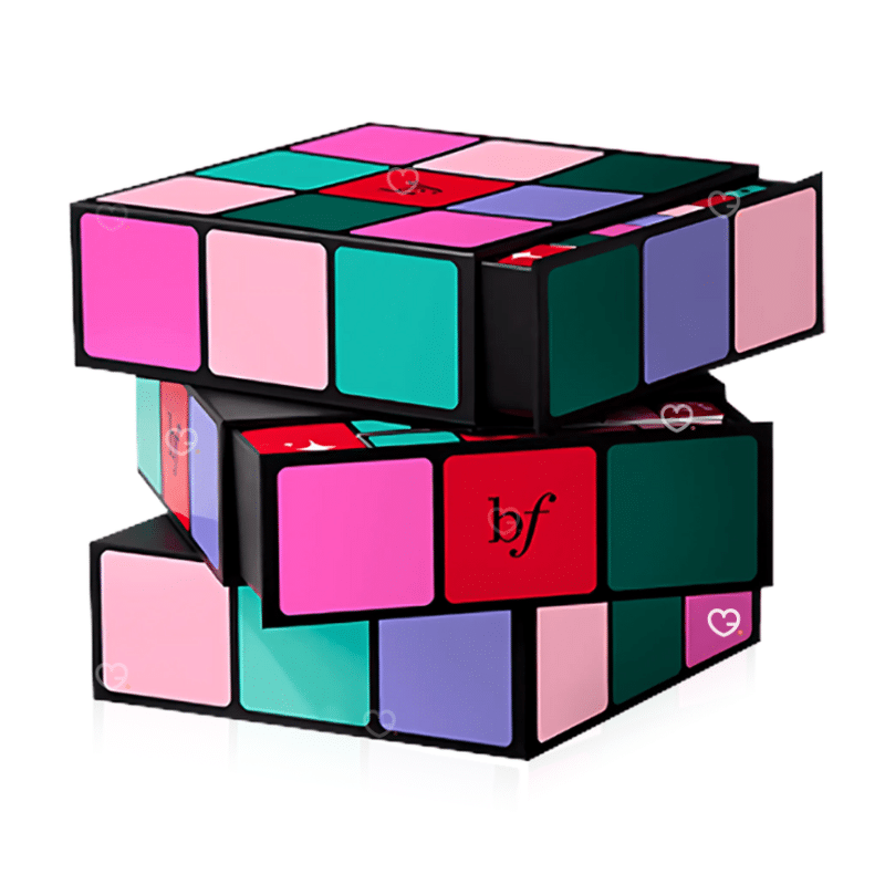 Calendrier de l’Avent Benefit 2025 The Glam Cube avec 24 surprises beauté et maquillage, incluant mascaras, blush et soins sourcils.